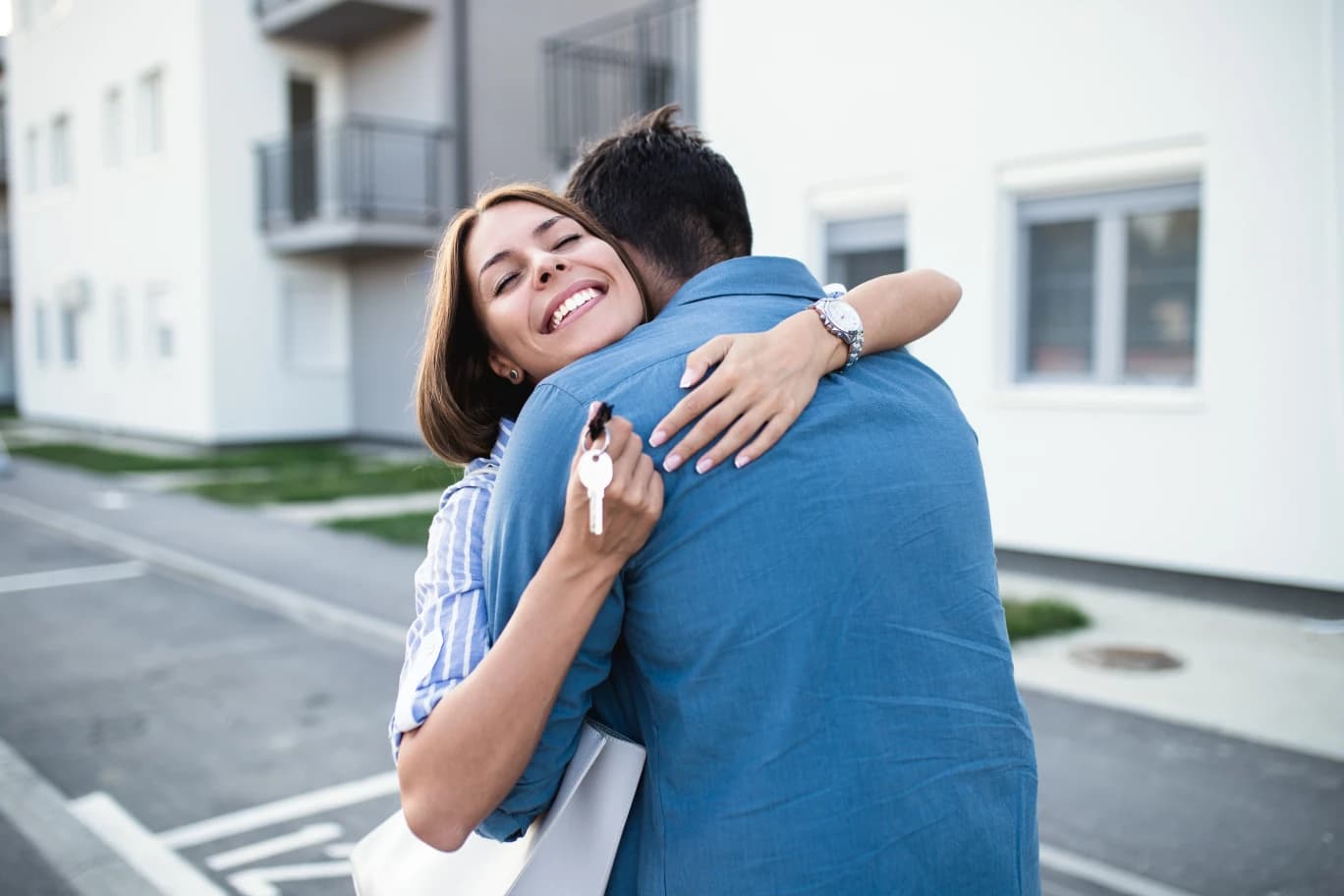 young-canadian-couple-standing-in-front-of-their-new-home-holding-house-keys-in-hand